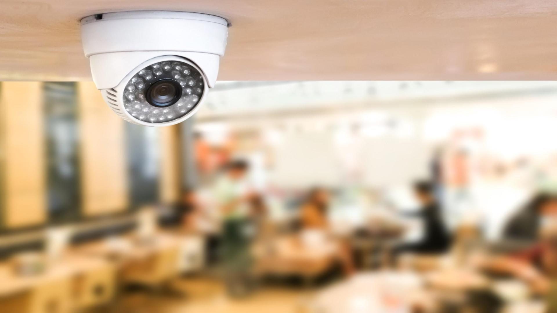 A security surveillance camera installed on the ceilling of an office.